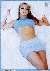 Britney Spears recumbant on white bed in sky-blue top and baby-blue mini-skirt